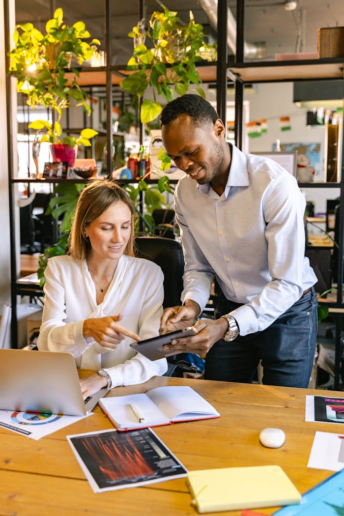 A diverse team collaborating in an office, using digital devices for productivity.